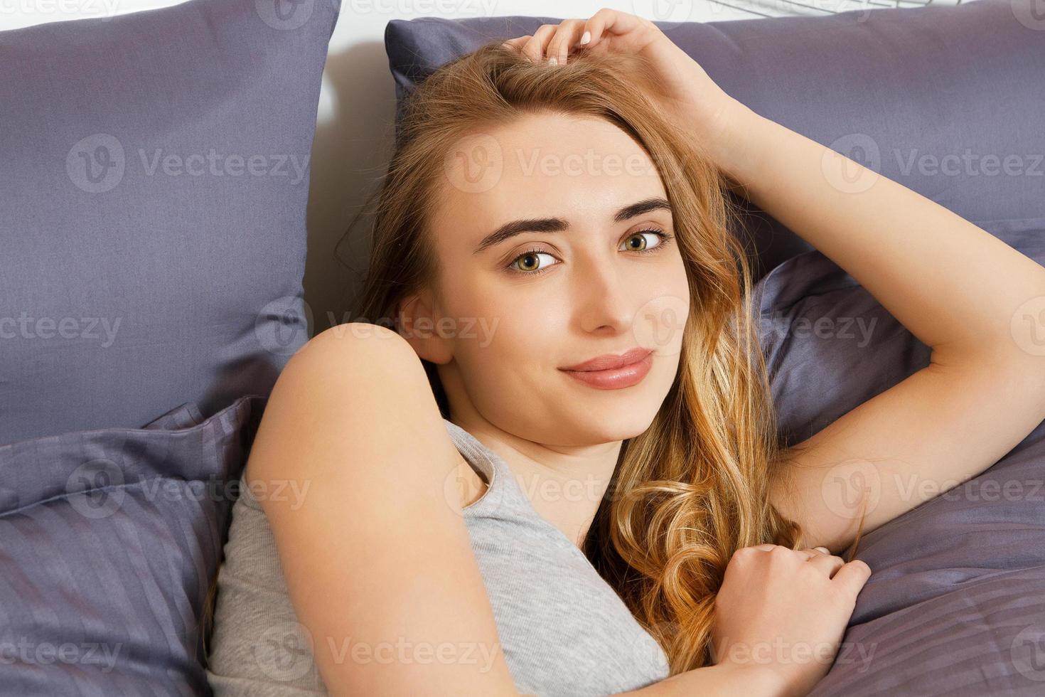 retrato de una bella sonrisa en la cama después de dormir foto