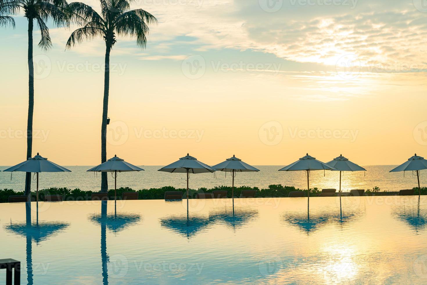 umbrella with bed pool around swimming pool with ocean sea background
