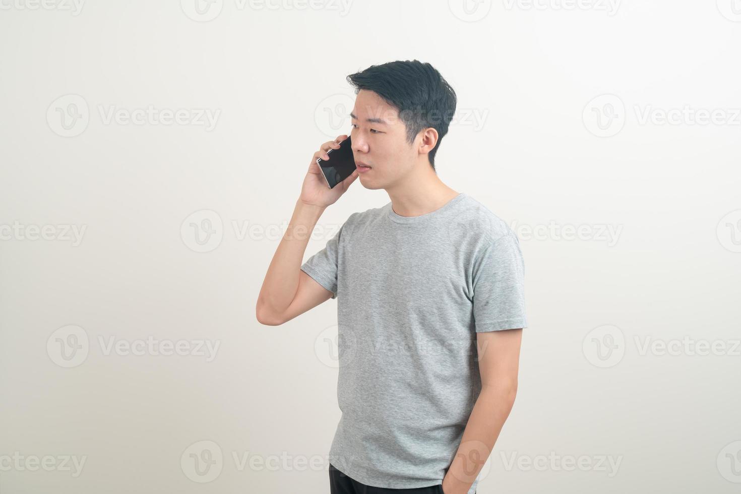 young Asian man using or talking smartphone and mobile phone photo