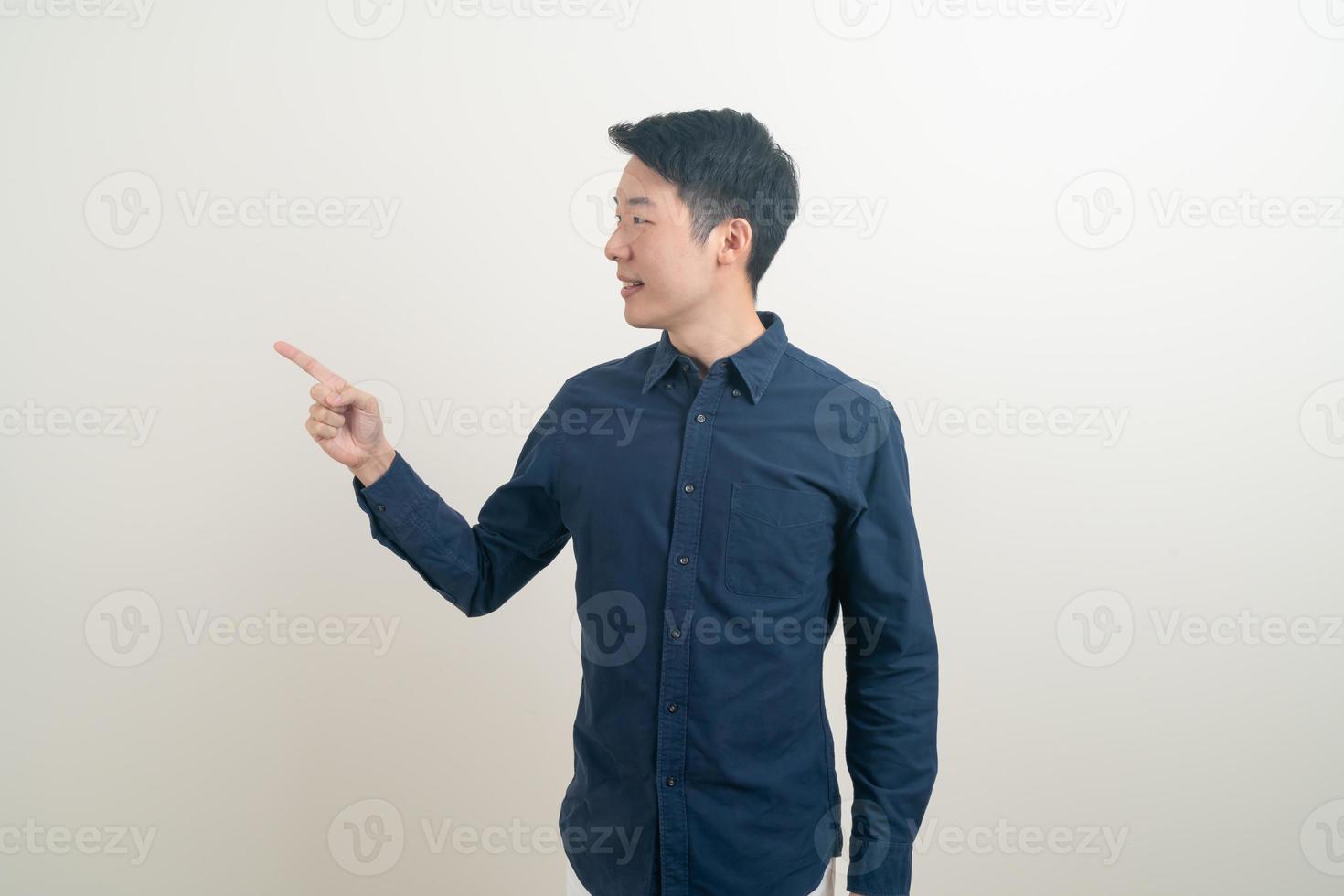 Hombre asiático con la mano apuntando o presentando sobre fondo blanco. foto