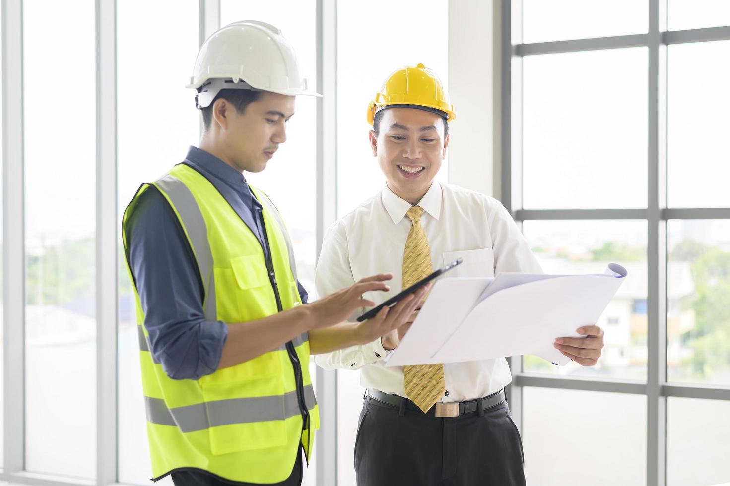 los ingenieros son planes de construcción analíticos con planos en la oficina foto