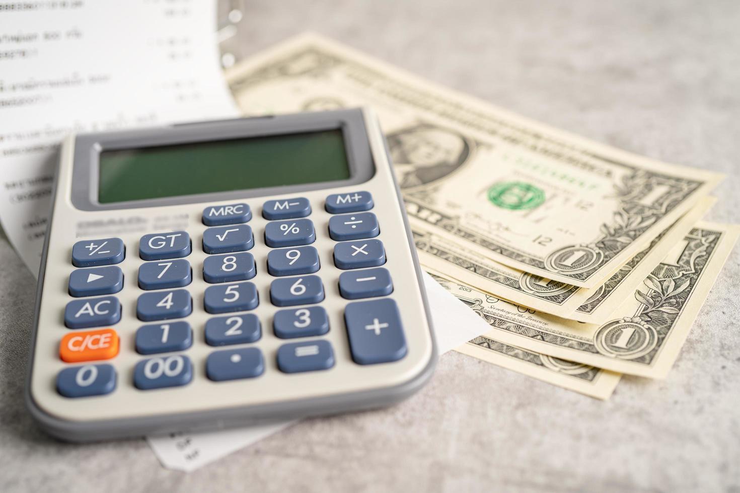 Grocery shopping list receipts with calculator and US dollar banknotes money. photo