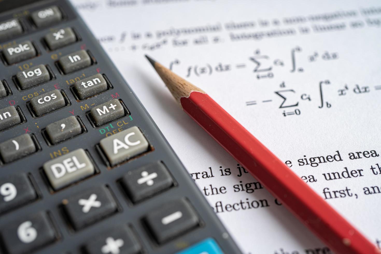 Pencil and calculator on mathematic formula exercise test paper in education school. photo