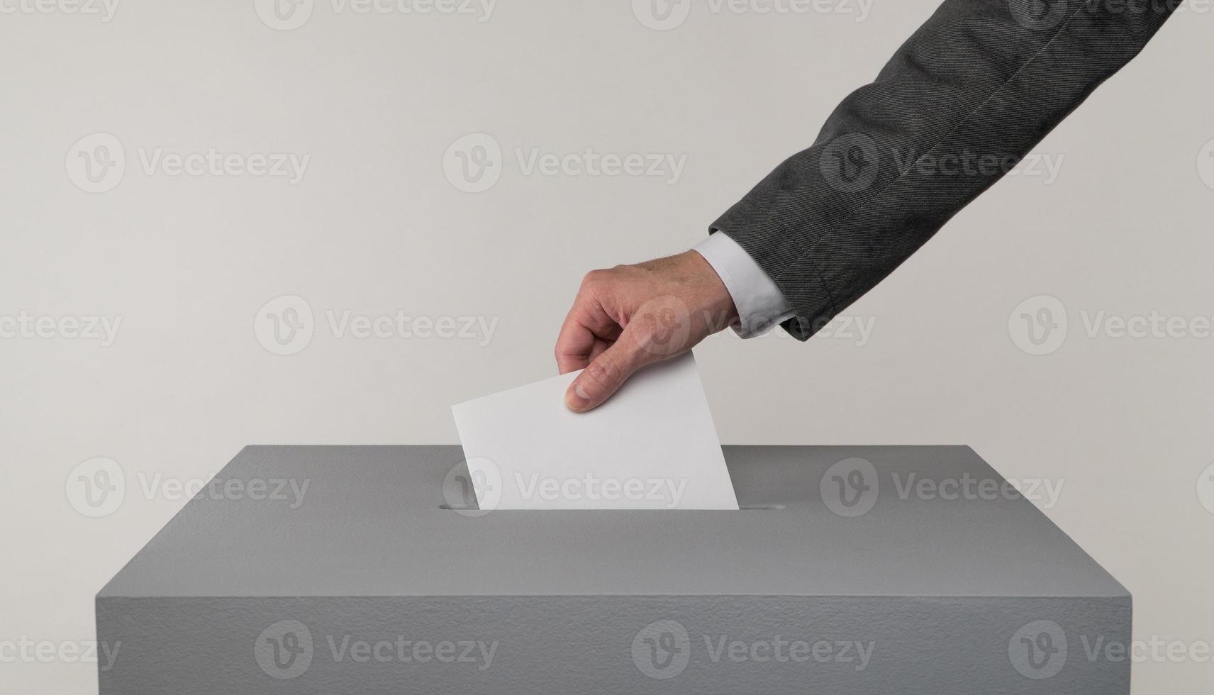 Gray ballot box. Presidential and parliamentary elections. The voter throws the ballot into the ballot box photo