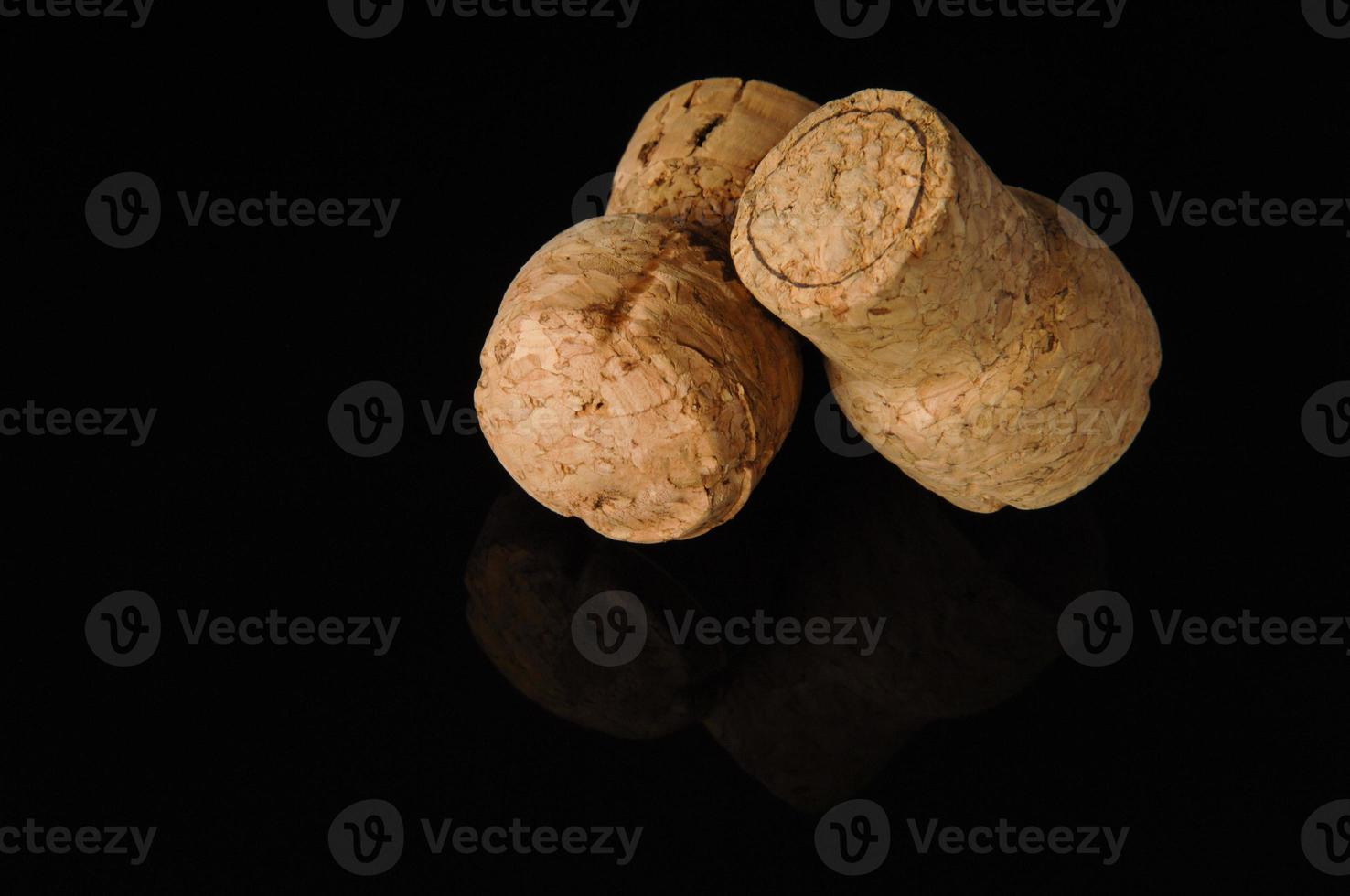 Two old wine corks on a black background with reflection photo