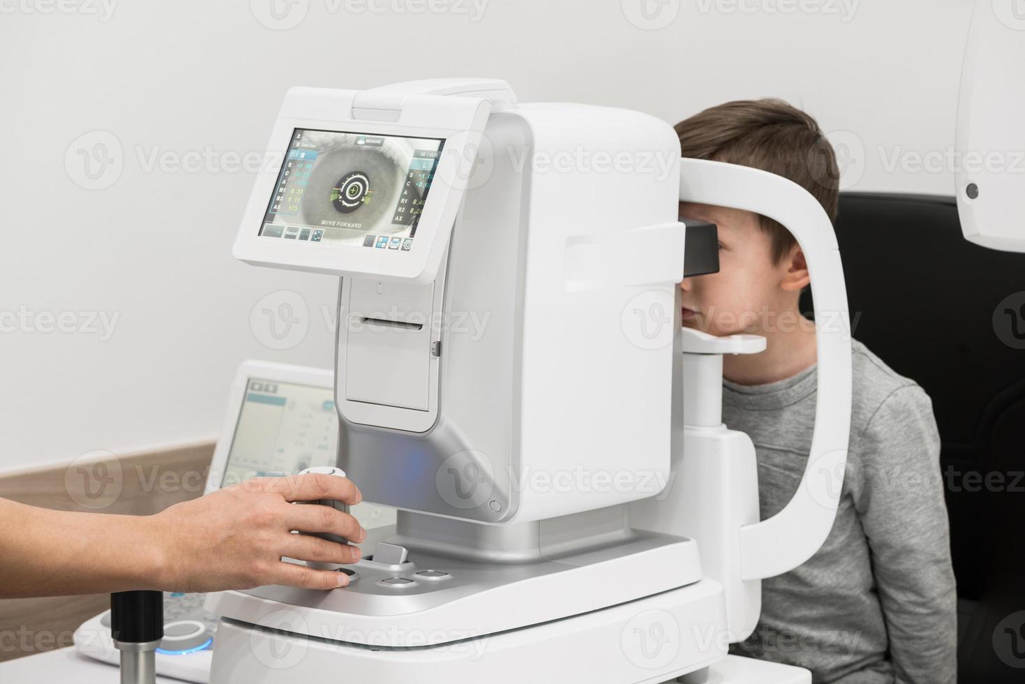 el niño es el paciente en la recepción del médico oftalmólogo. equipo de diagnóstico oftalmológico. concepto de medicina foto