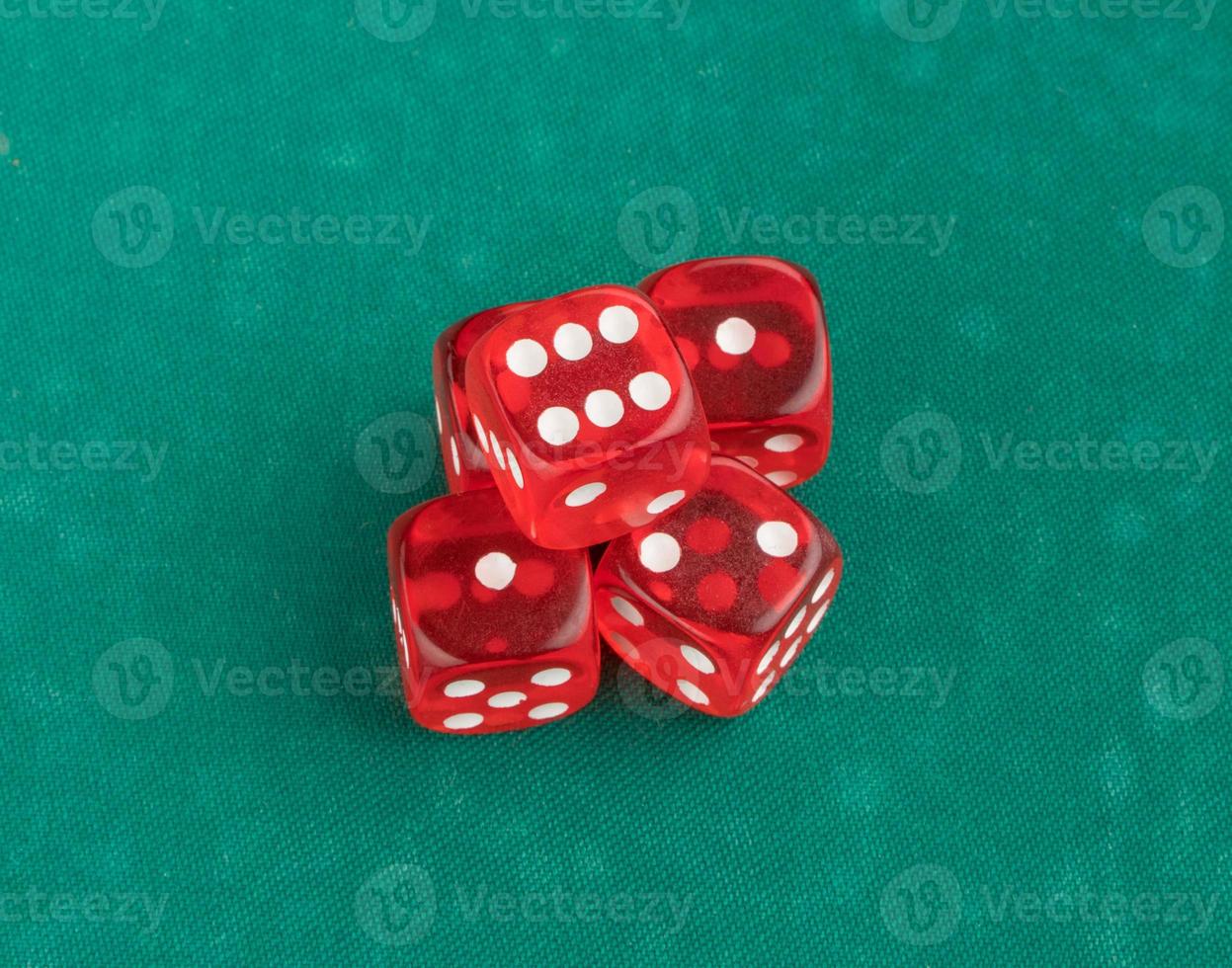 group of red playing dice on a green background, isolated. top view photo