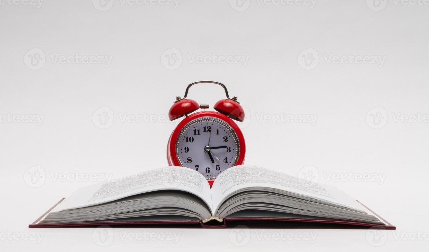 red alarm clock and open book on white background, isolated. back to school photo