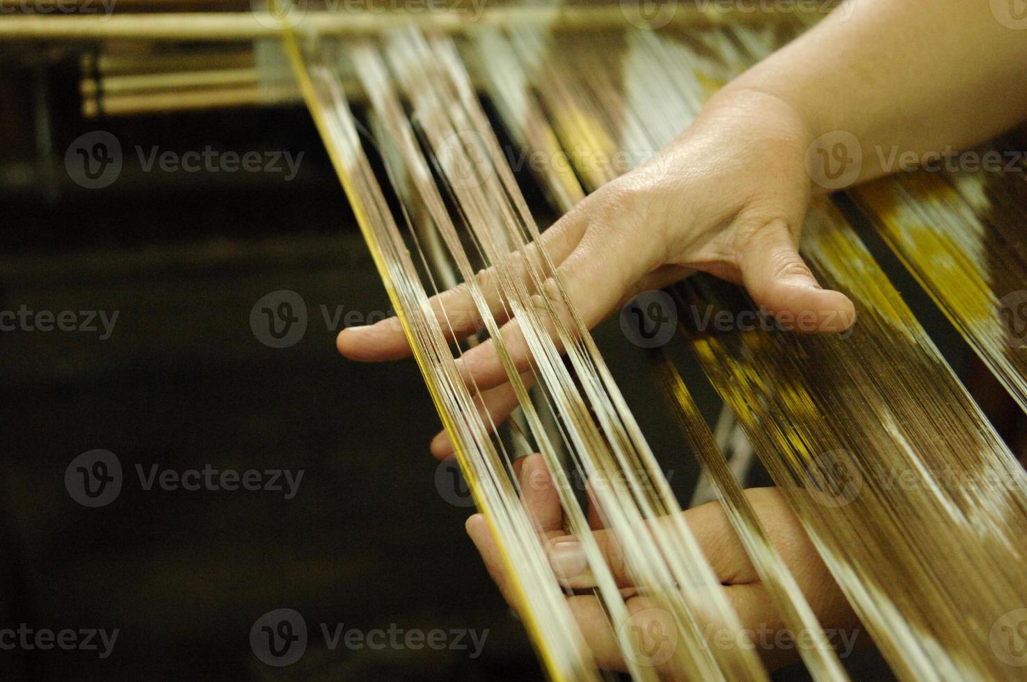 weaving and manufacturing of handmade fabric close up. women's hands behind a loom make cloth photo