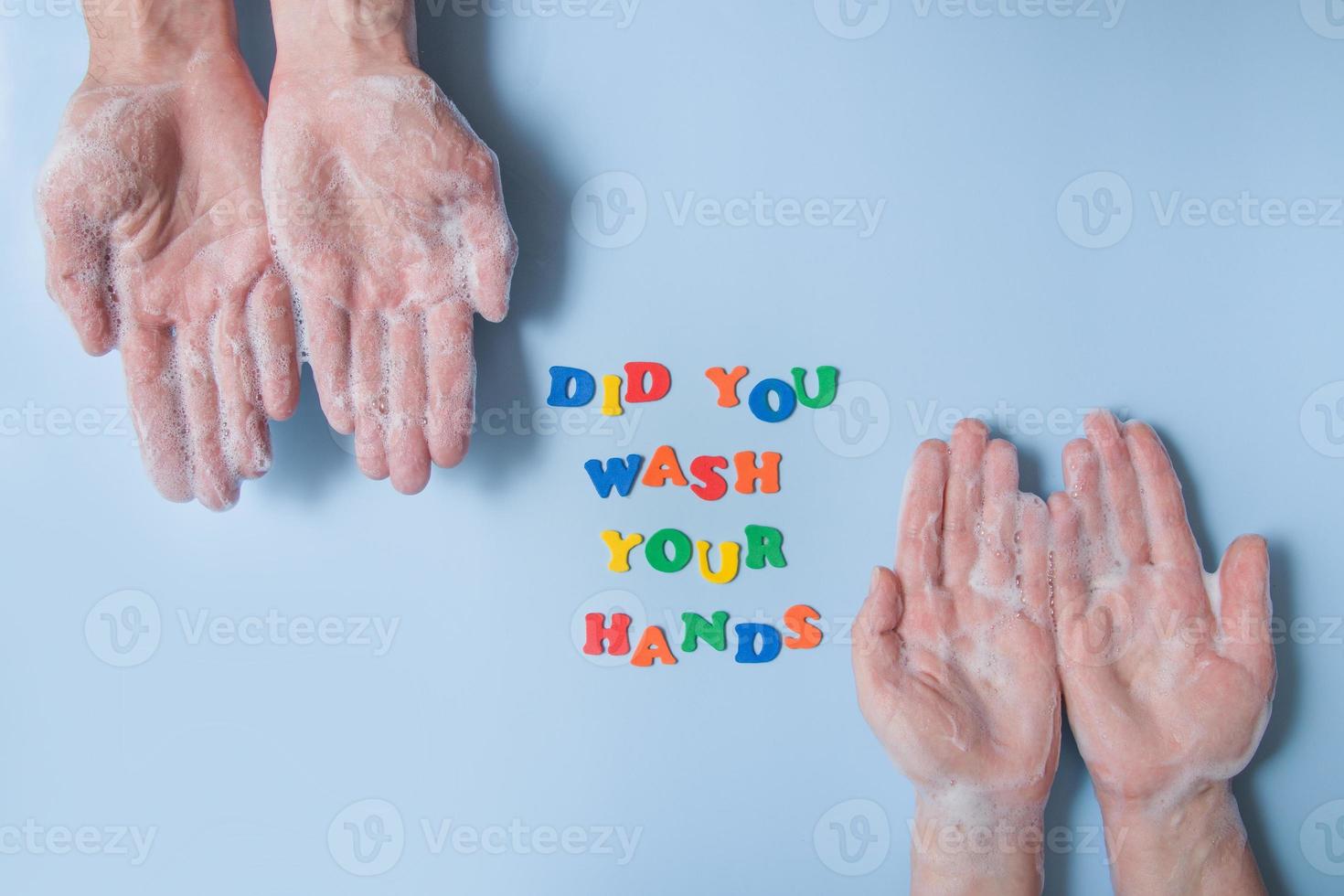 Colored text did you wash your hands next to your hands in foam on a blue background photo