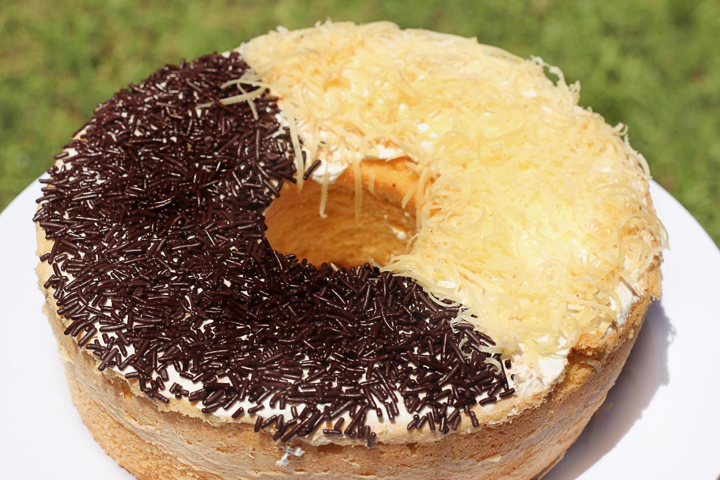 Homemade round sponge cake chocolate and cheese on white table. photo