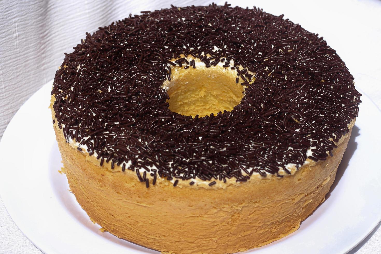 Homemade round sponge cake chocolate on white table. photo