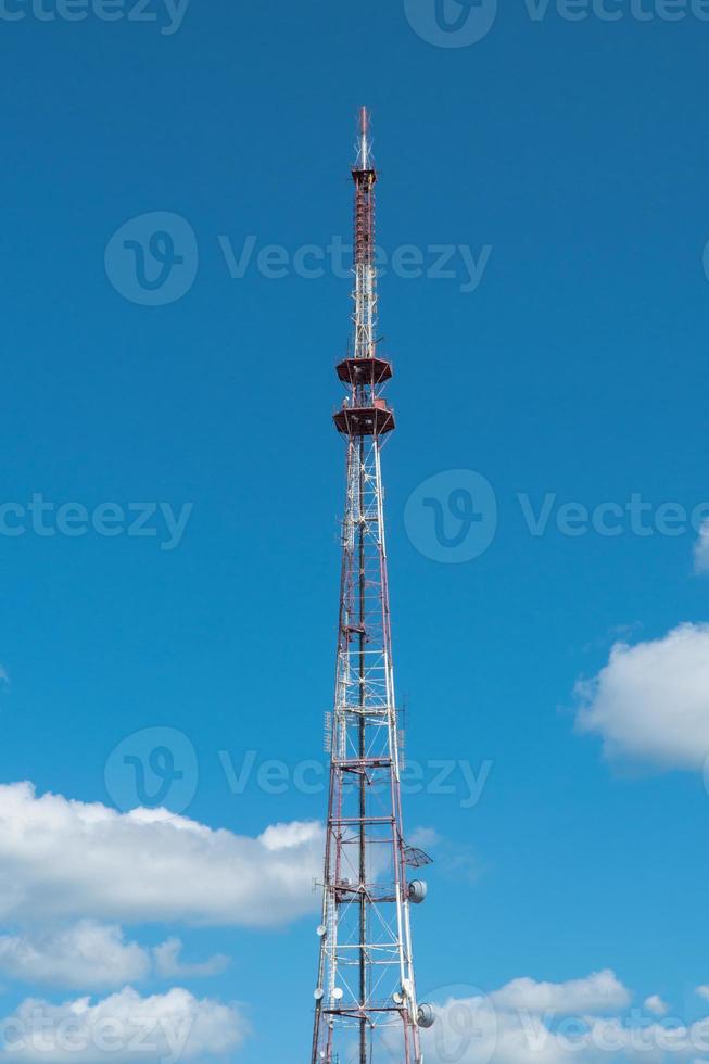 telecommunication tower with antennas on the background of the sky with clouds photo