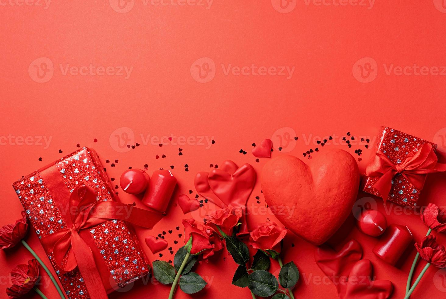 Valentines Day gifts, roses and candles on red backdrop, copy space photo