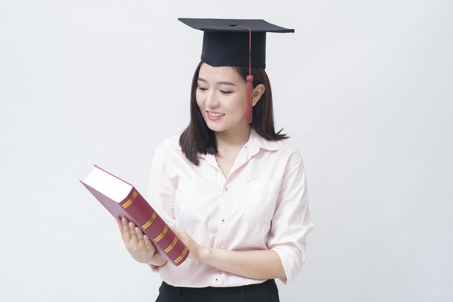 A portrait of beautiful young asian woman with education cap over white background Studio, Education concept . photo