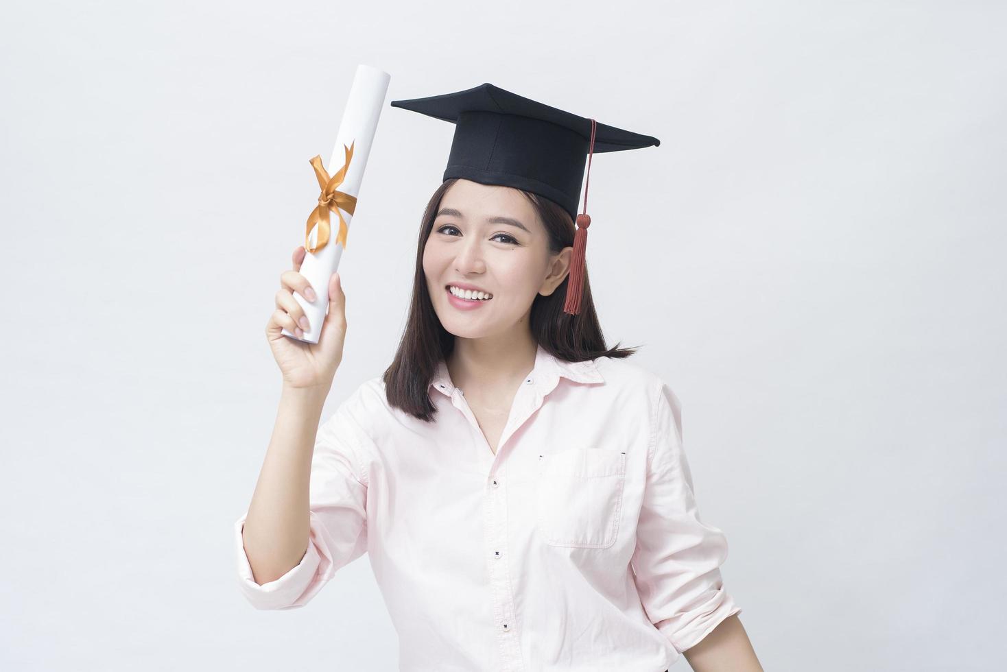 un retrato de una hermosa joven asiática con gorra de educación sobre estudio de fondo blanco, concepto de educación. foto
