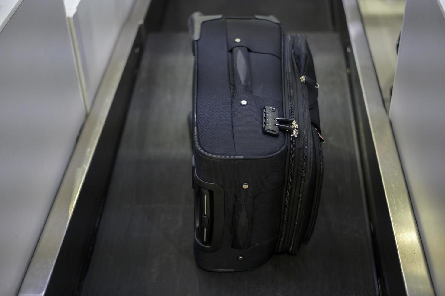 Luggage on weight on the conveyor belt at check-in counter at airport photo