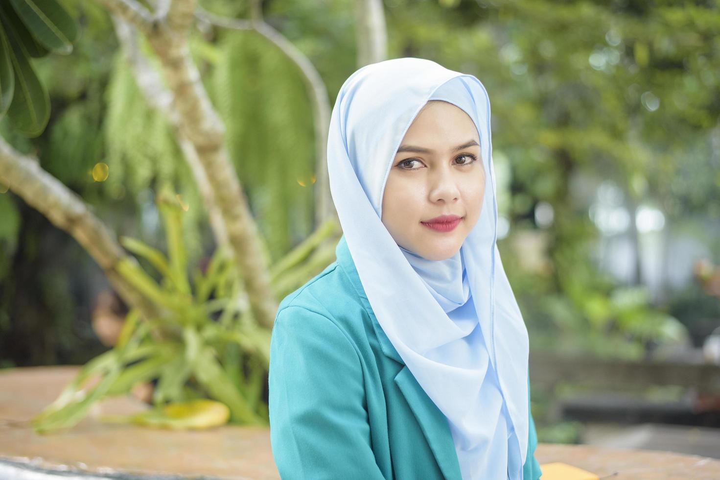 Muslim woman with hijab is working with laptop computer in coffee shop photo