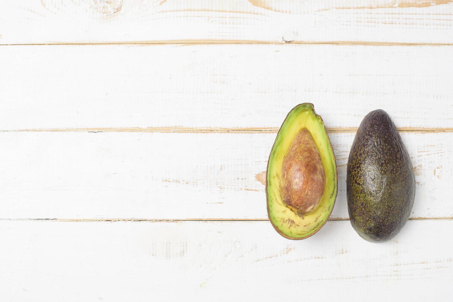 Avocado on white wooden table photo