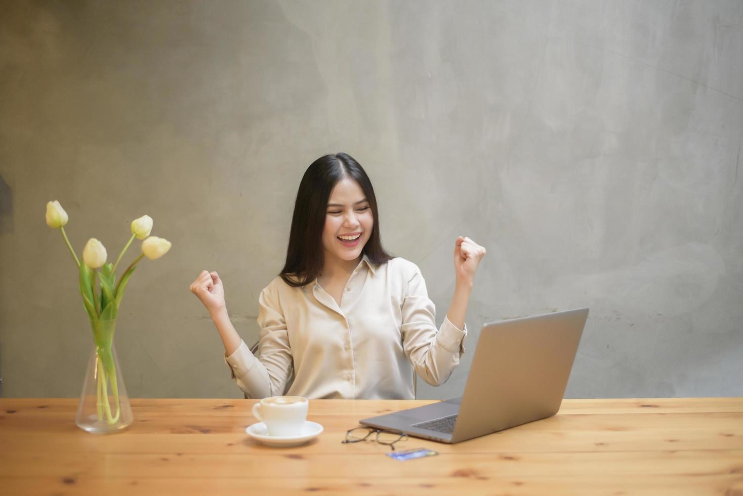 Beautiful business woman is working with laptop in coffee shop photo