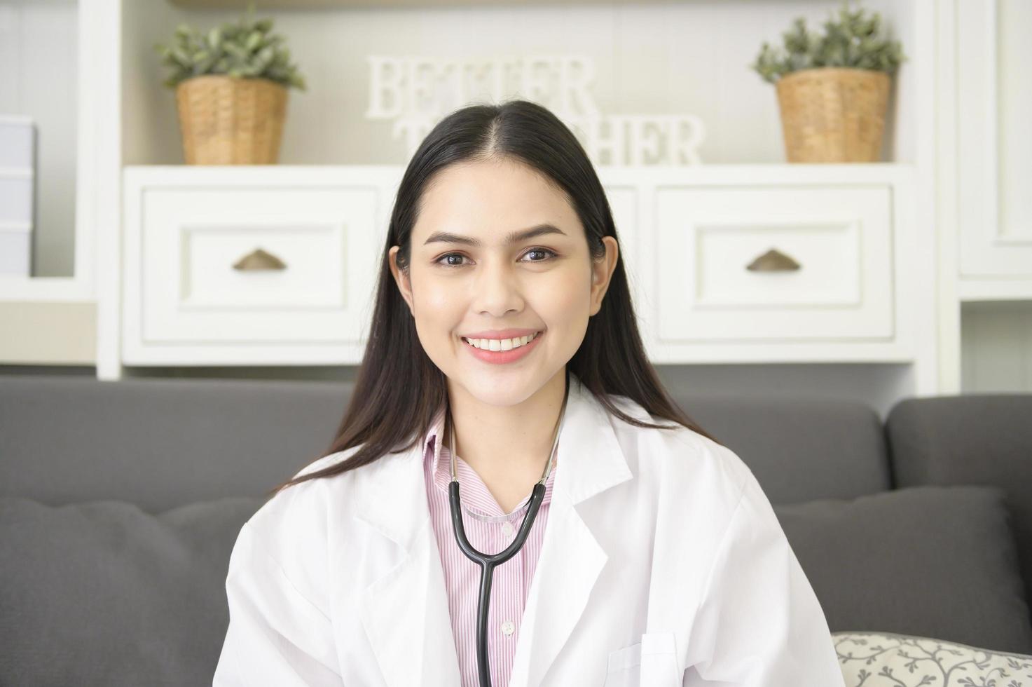 retrato de una doctora con estetoscopio en la oficina y sonriendo a la cámara. foto