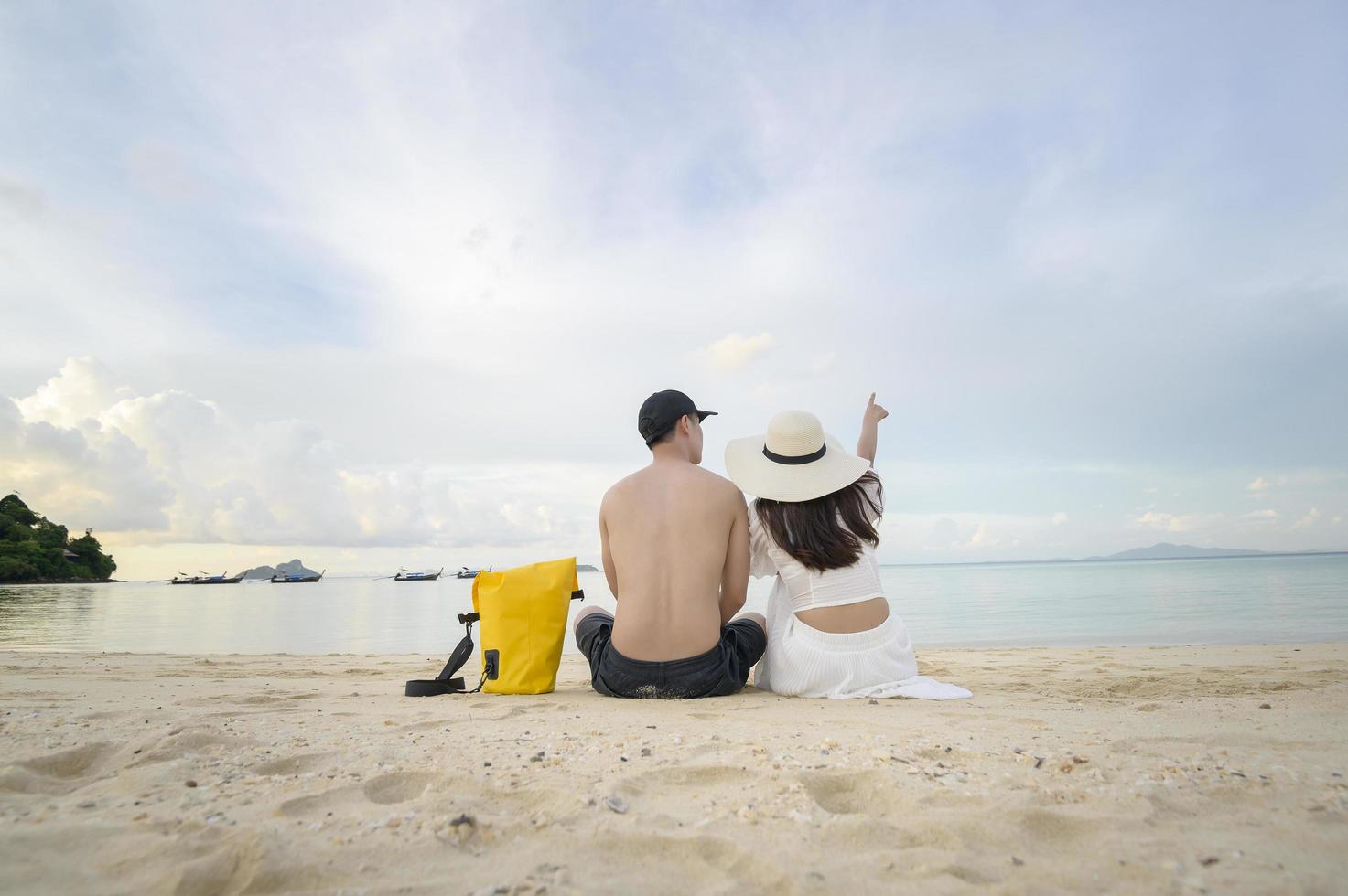 una pareja feliz disfrutando y relajándose en el concepto de playa, verano y vacaciones foto