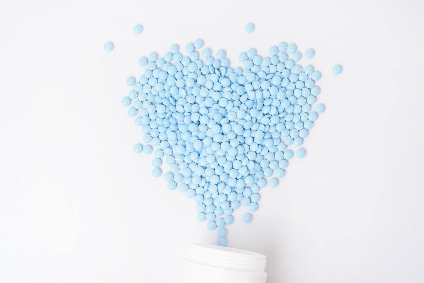 Heaps of blue pills on white background photo