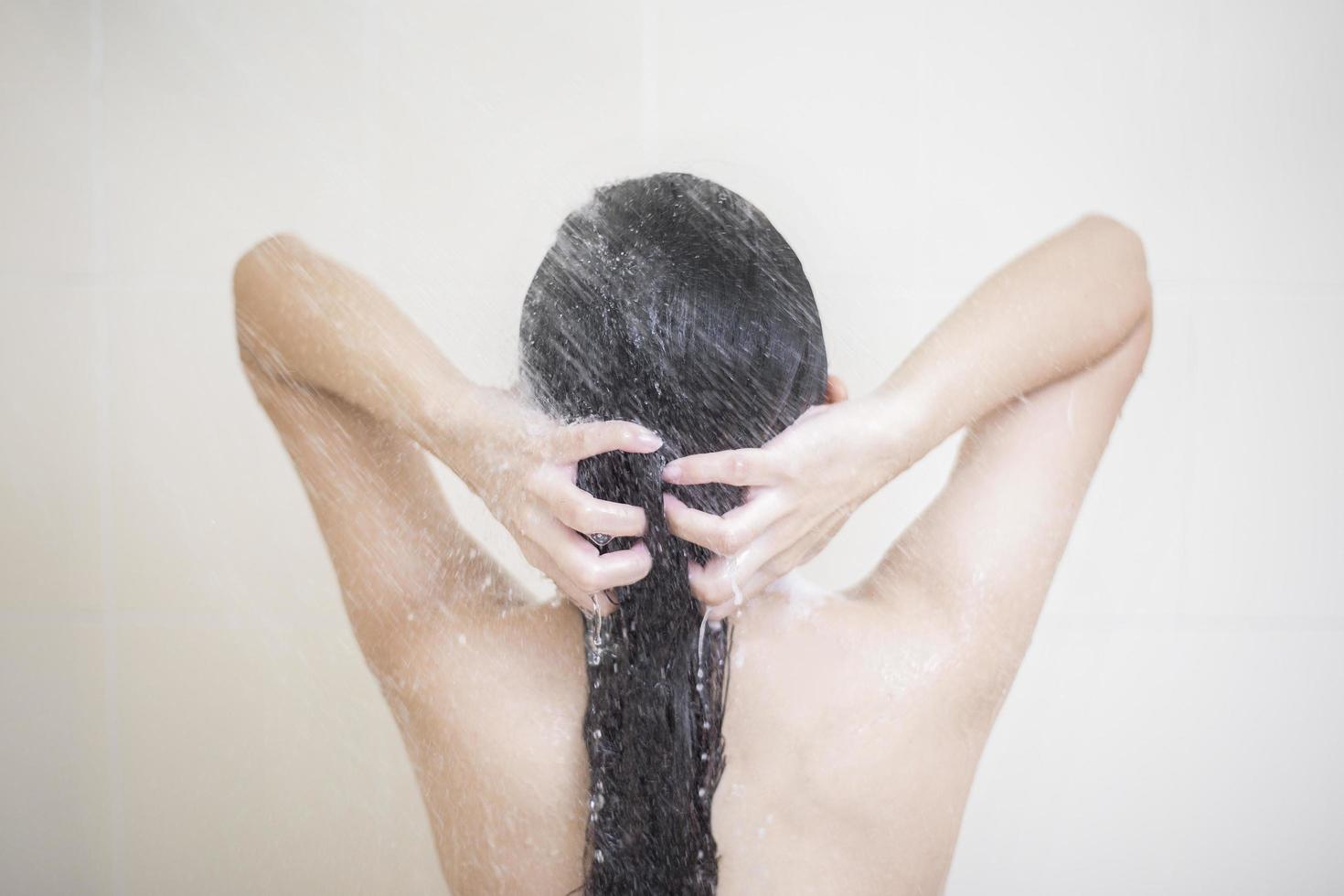 Happy  beautiful woman is taking a shower photo