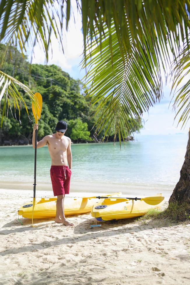 un joven deportista haciendo kayak en el océano en un día soleado foto