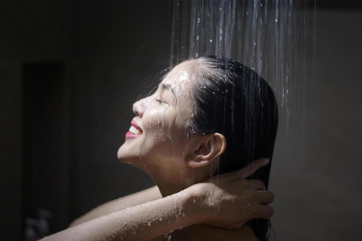 joven hermosa mujer lavándose el pelo en un baño en casa foto