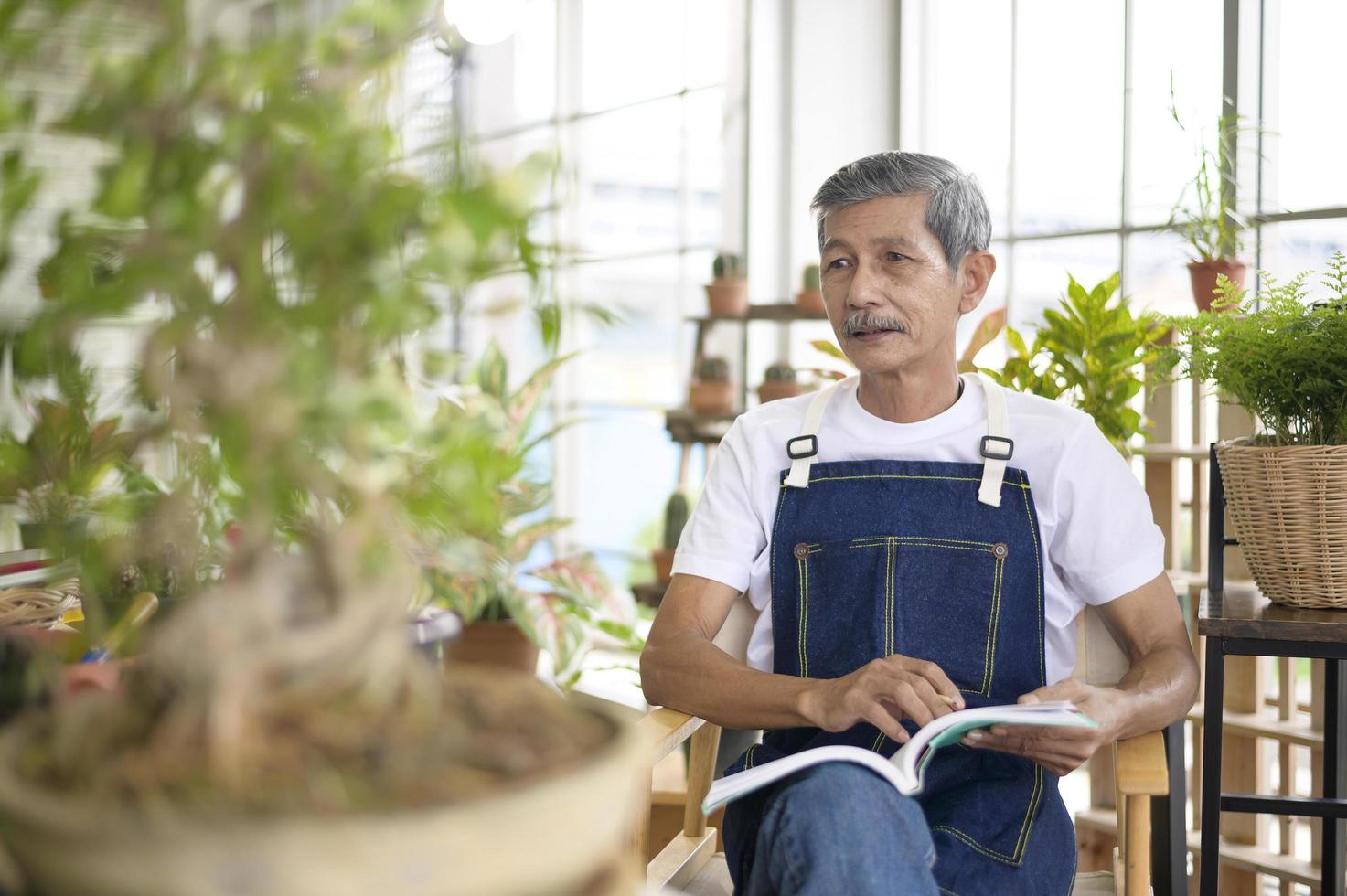 happy senior asian retired man reading and enjoying  leisure activity in garden at home. photo