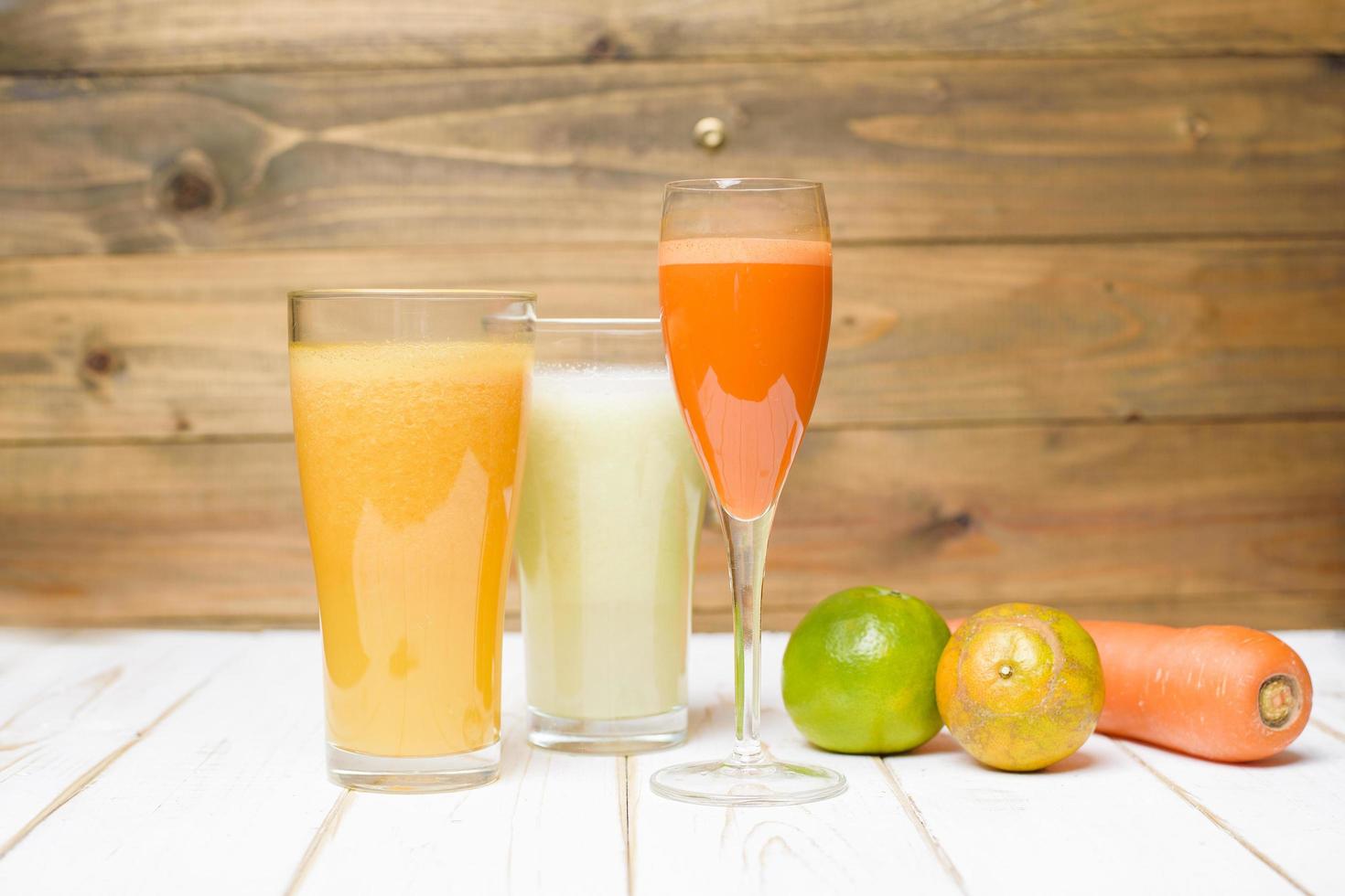 Jugo de frutas y verduras de dieta saludable listo para beber en mesa de madera foto