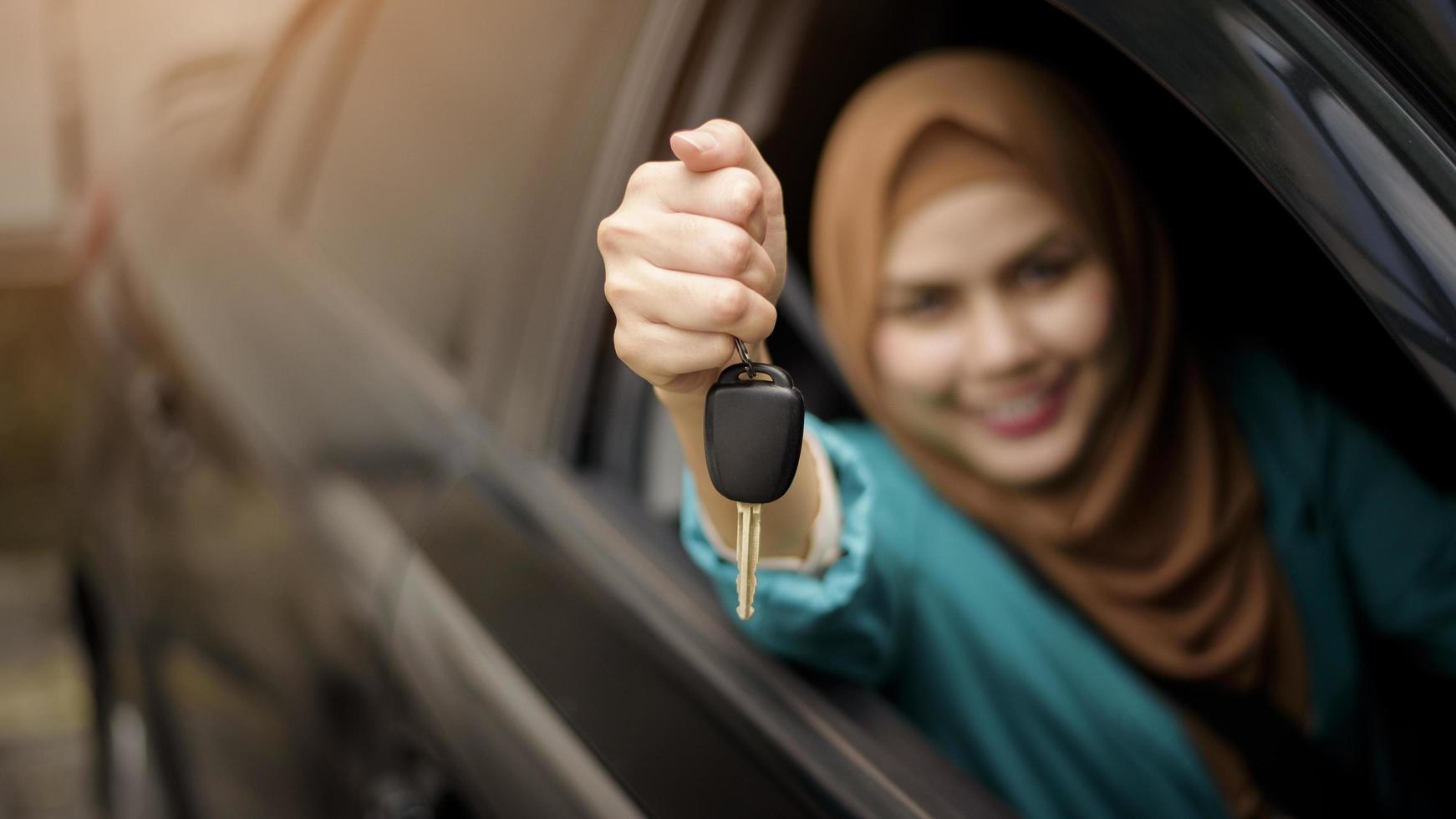 Beautiful businesswoman with hijab is smiling in her car photo