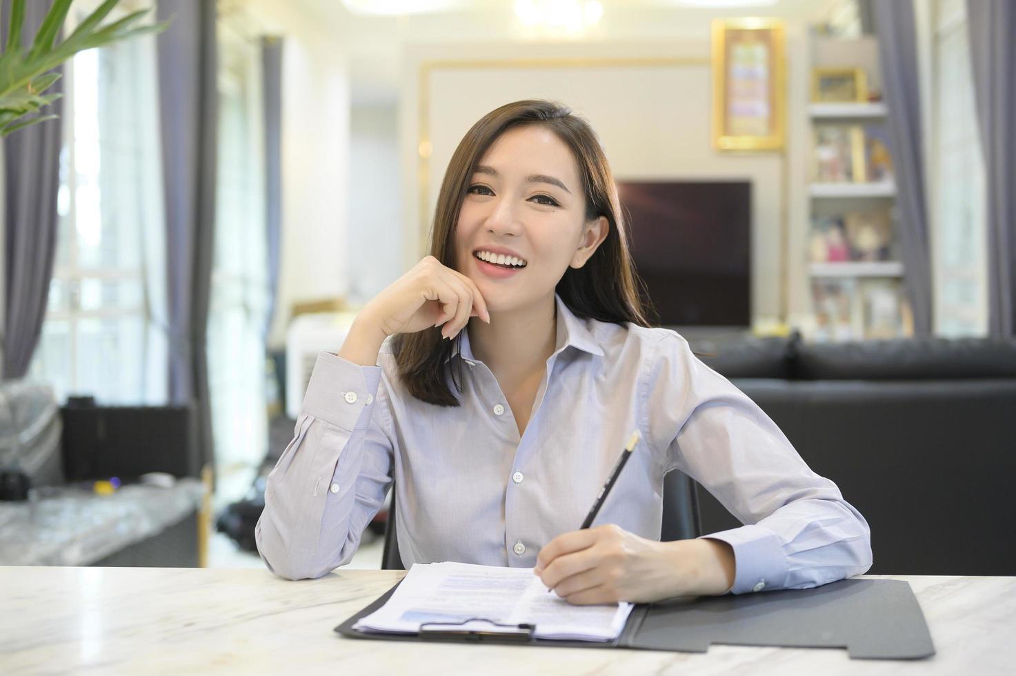 Headshot screen view of young Asian businesswoman is online using Video conference with partners or business coworkers  from her home . photo