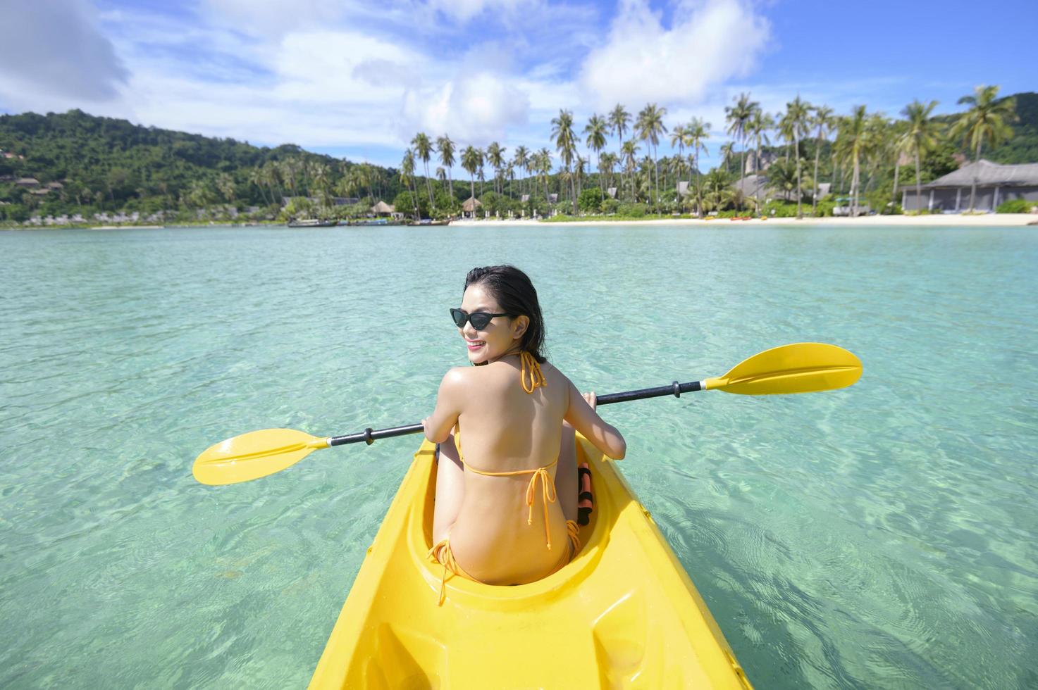 joven deportista haciendo kayak en el océano en un día soleado foto