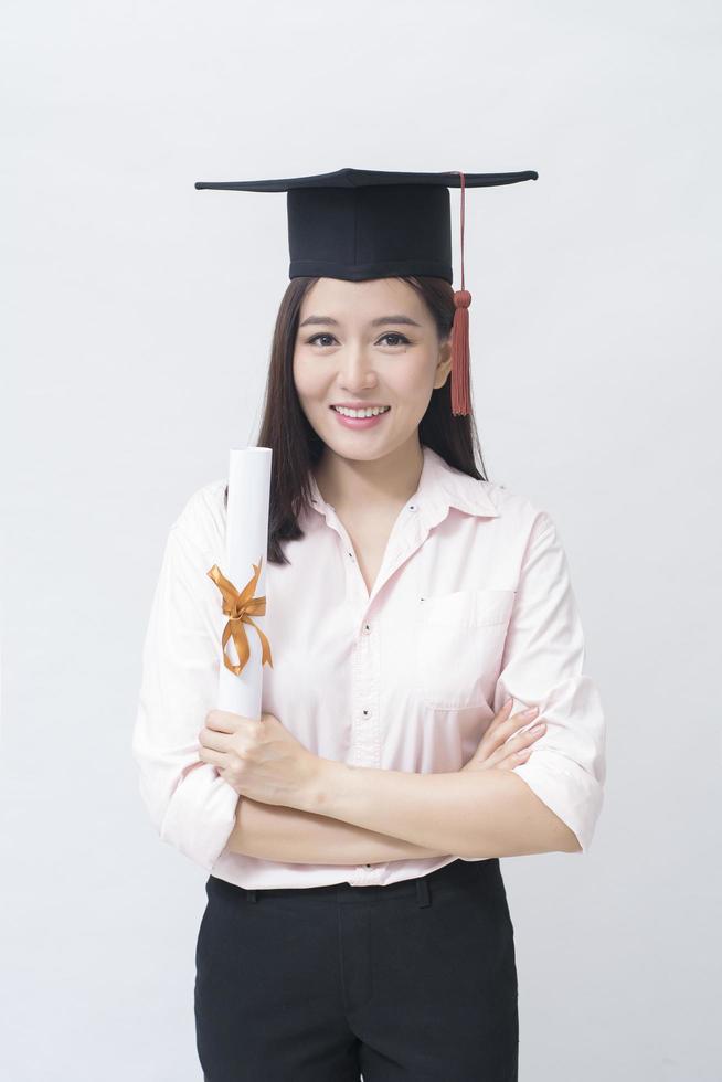 A portrait of beautiful young asian woman with education cap over white background Studio, Education concept . photo