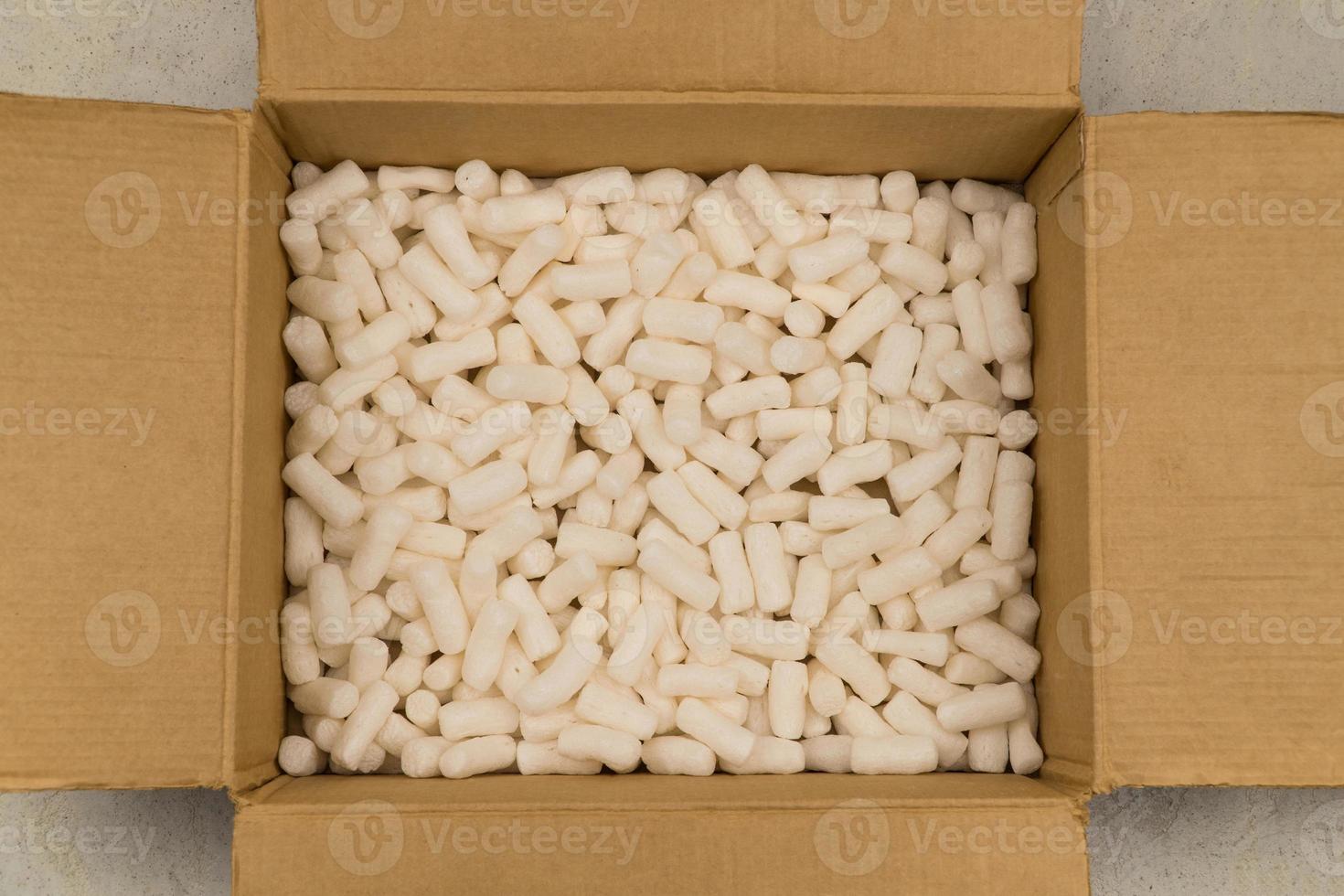 Empty cardboard box with styrofoam filler for safe packaging. Top view photo