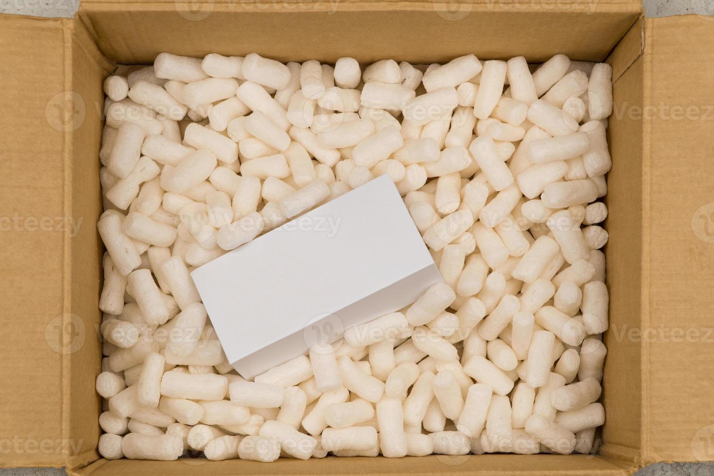 Cardboard box with styrofoam filler for safe packaging. Gift package. Top view photo