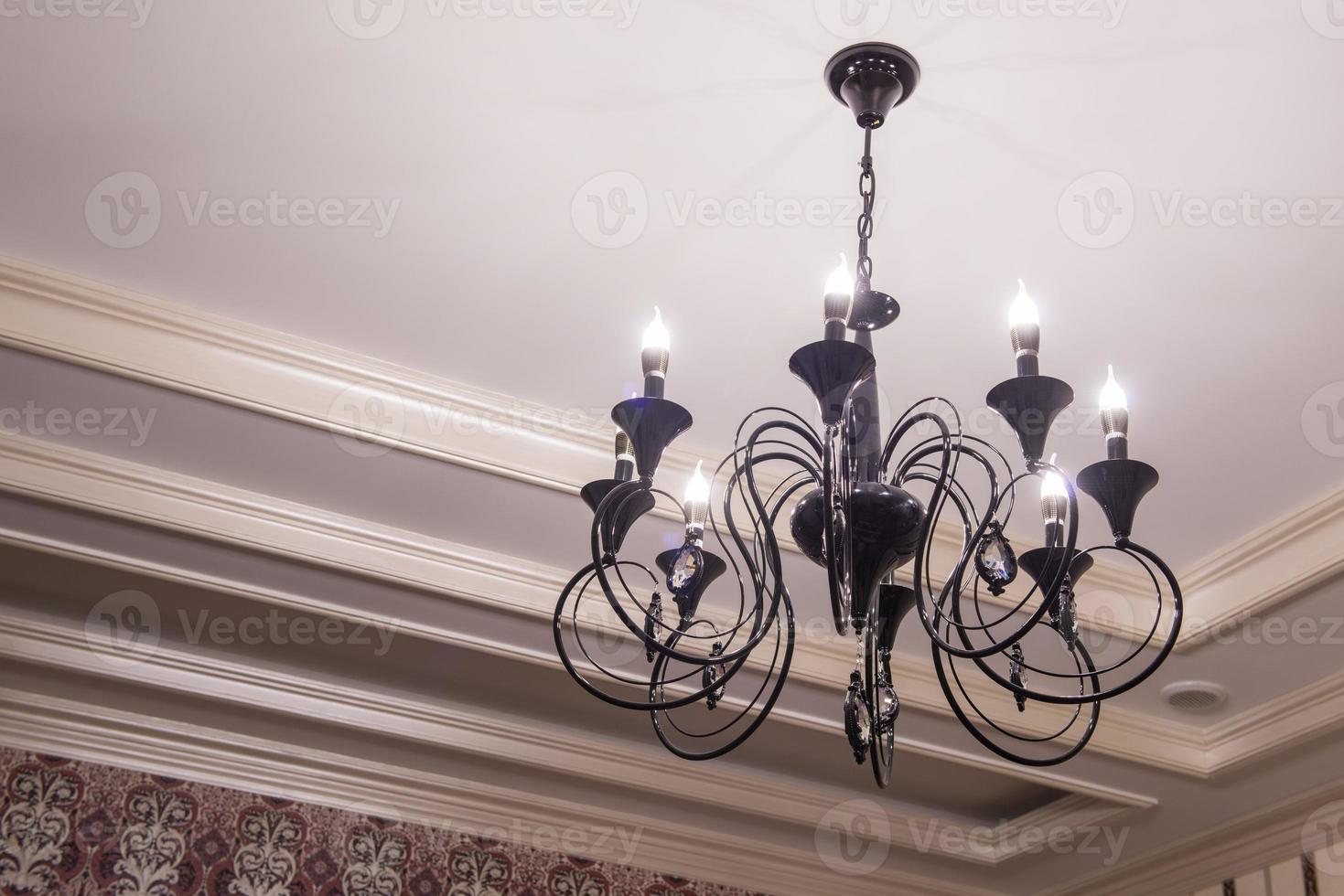 luxurious black metal chandelier hanging on the ceiling photo