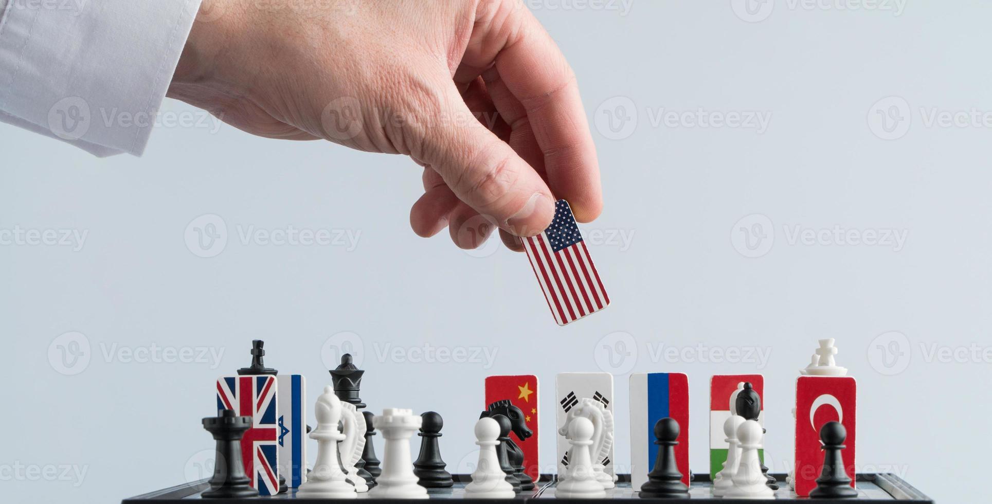 la mano del político mueve una pieza de ajedrez con una bandera. foto conceptual de un juego político. movimiento de represalia ee.uu.