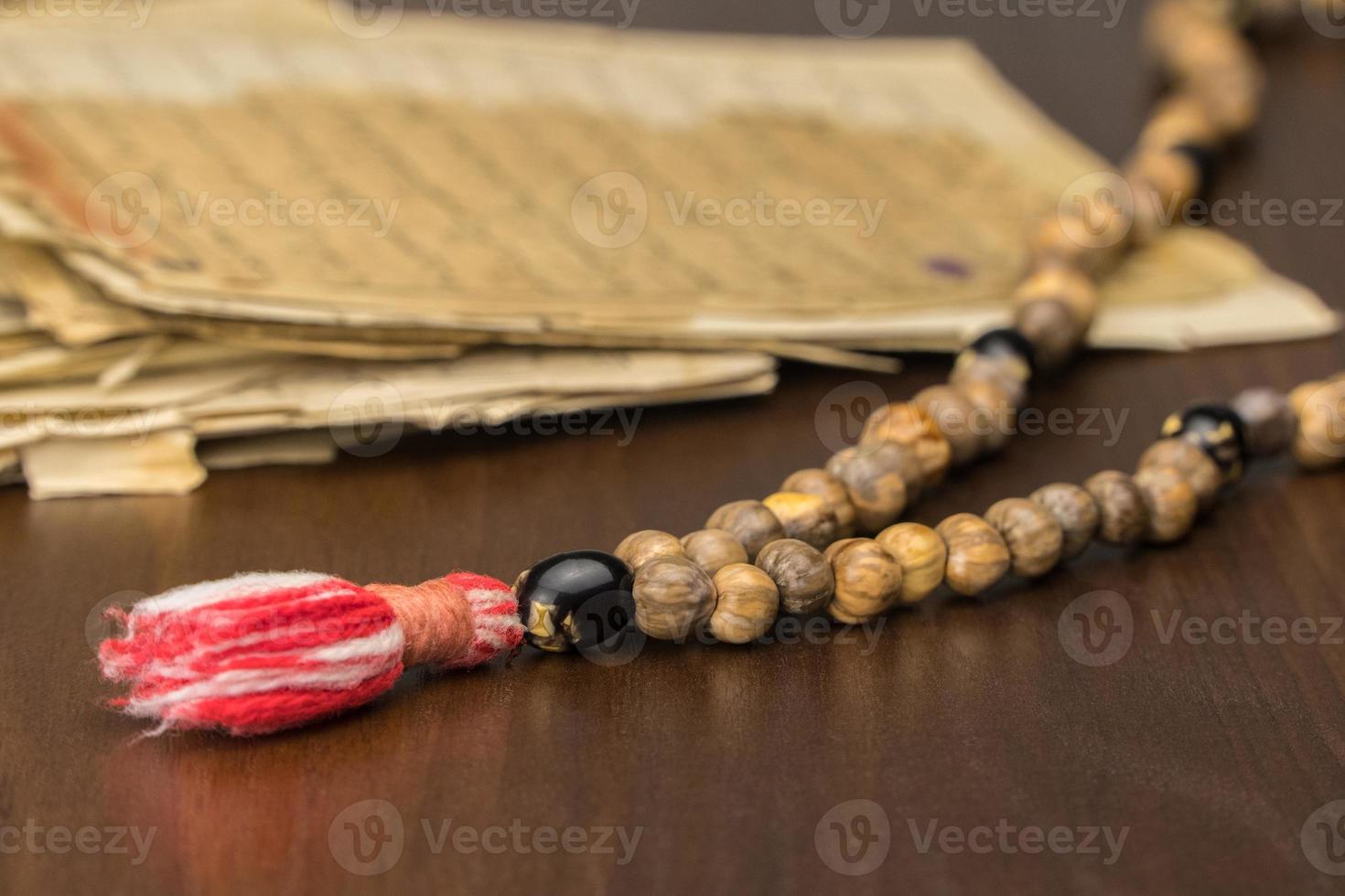 Muslim prayer beads with ancient pages from the Koran. Islamic and Muslim concepts. Ancient old sheets of paper from the Arabic book photo