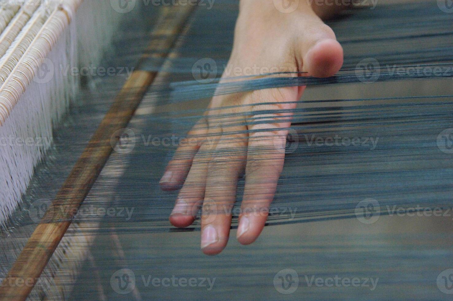 weaving and manufacturing of handmade fabric close up. women's hands behind a loom make cloth photo