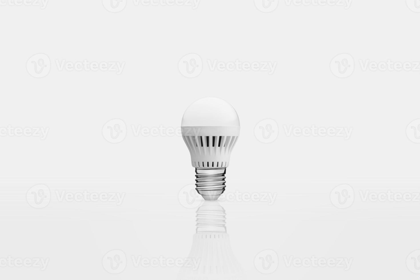 one energy saving lamp on a white background with reflection photo