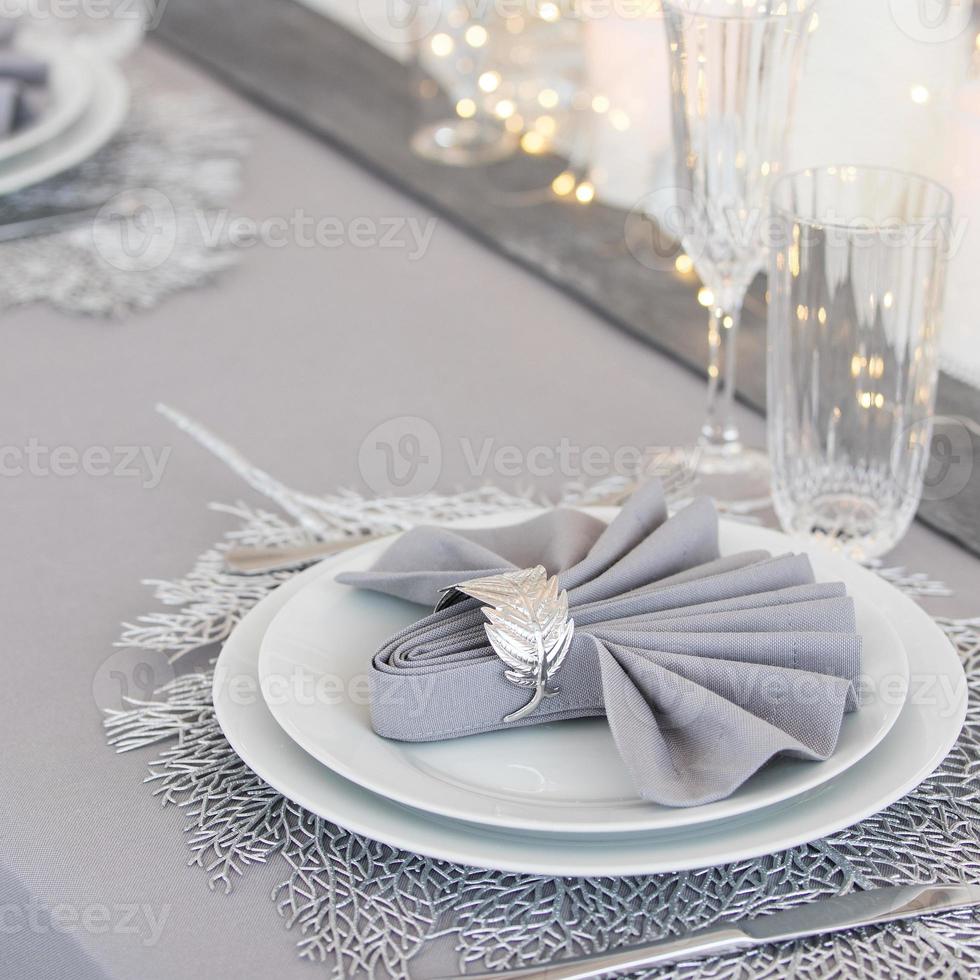 Beautiful table setting with Christmas decorations. Silver colors photo