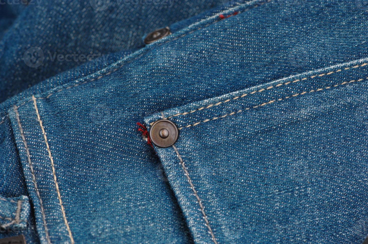 part of the blue denim pants with pockets and rivets, closeup photo