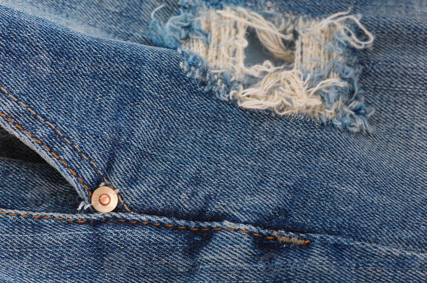 part of the blue denim pants with pockets and rivets, closeup photo