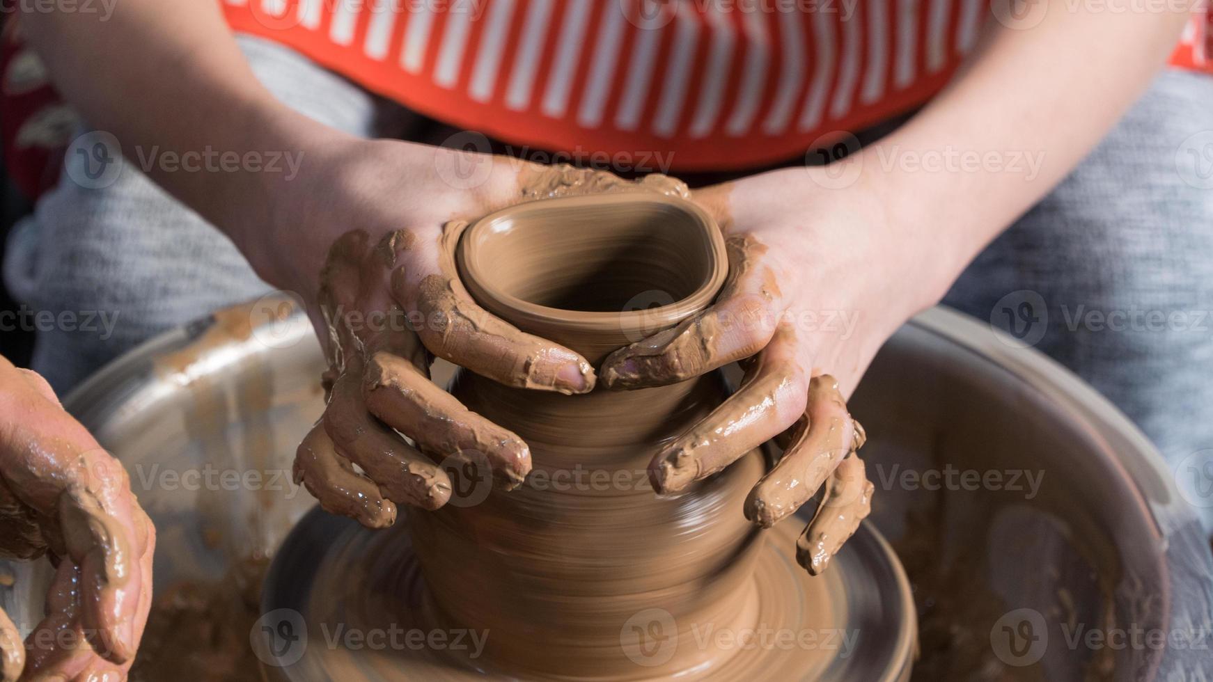 Teaching pottery to children. The teacher gives a master class in modeling photo