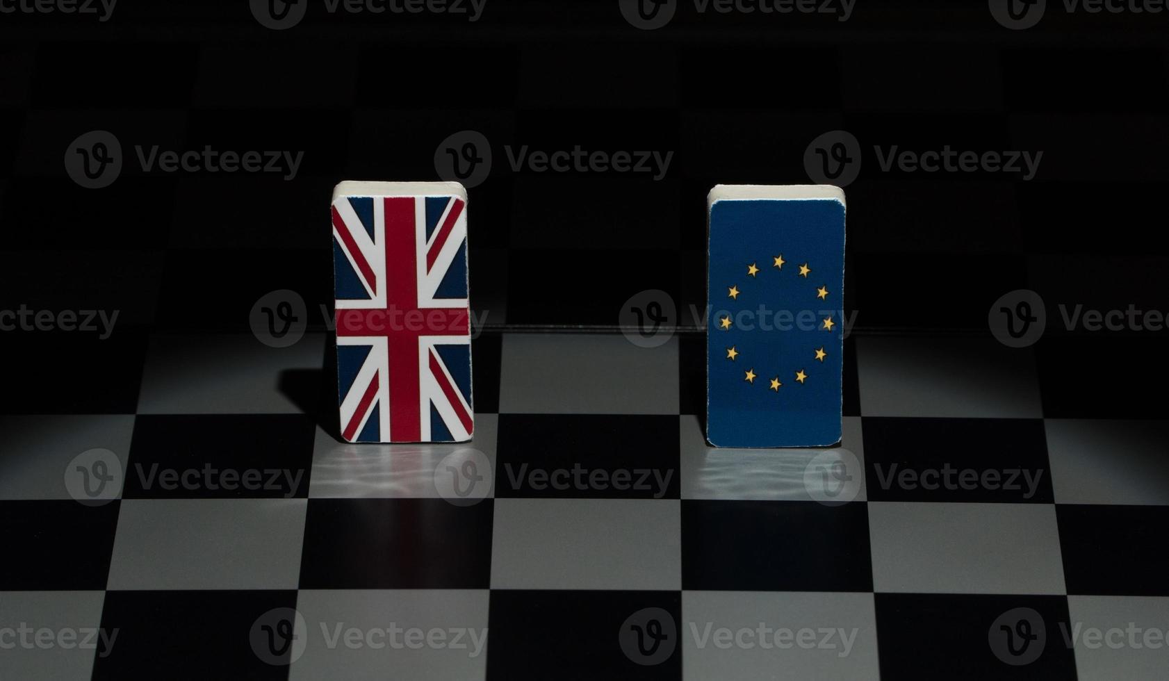 retroiluminado en las sombras figuras y banderas de la unión europea y gran bretaña en el tablero de ajedrez. el concepto del juego político y la estrategia de ajedrez brexit foto