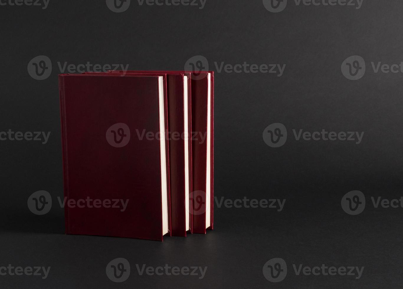 books with red cover on black background, isolated. back to school photo