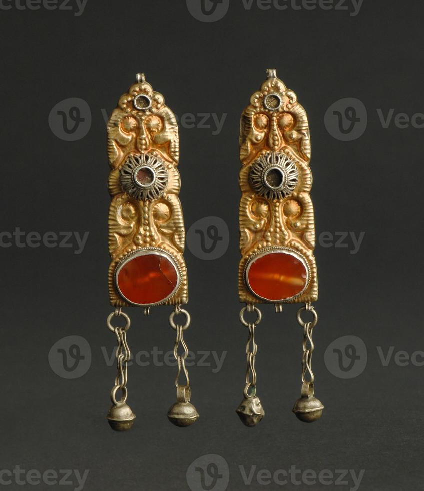 ancient antique earrings with stones on black background. Middle Asian vintage jewelry photo